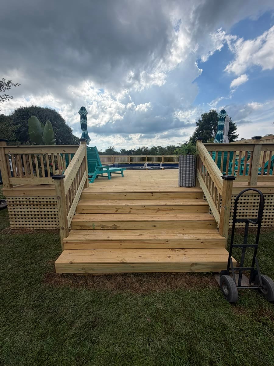 Wide timber deck steps with railings either side and lattice skirting under the deck.